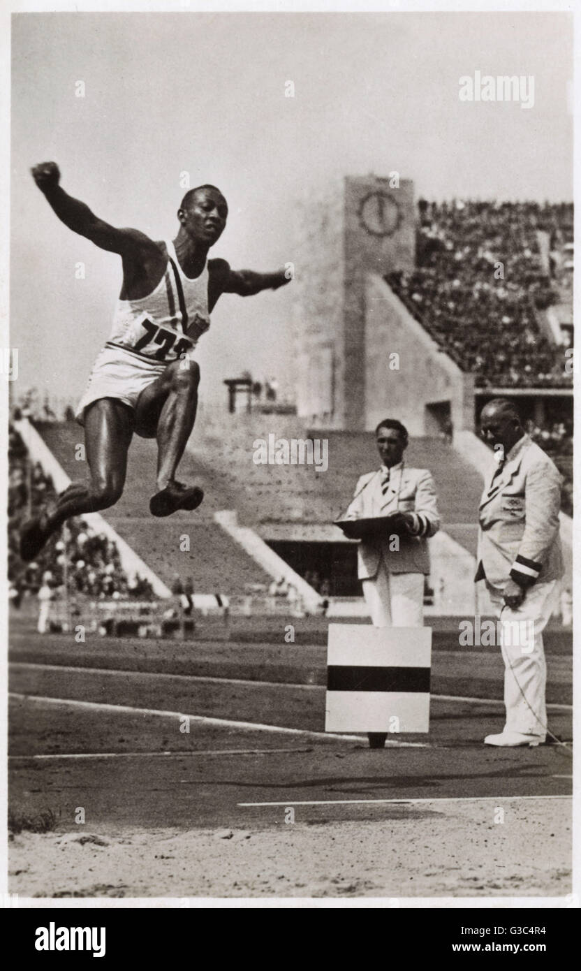 Jeux Olympiques de Berlin - Jesse Owens (1913-1980) au saut en longueur, la production de sa médaille d'or de saut de 26 pi 5 po (l'une des quatre médailles d'or qu'il a gagné à ce jeux). Date : 1936 Banque D'Images