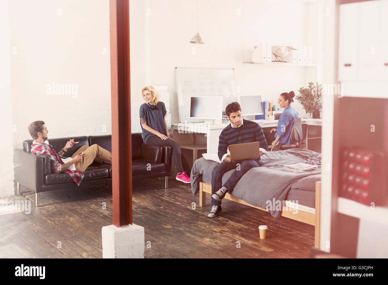 Young adult friends hanging out in loft Appartement Banque D'Images
