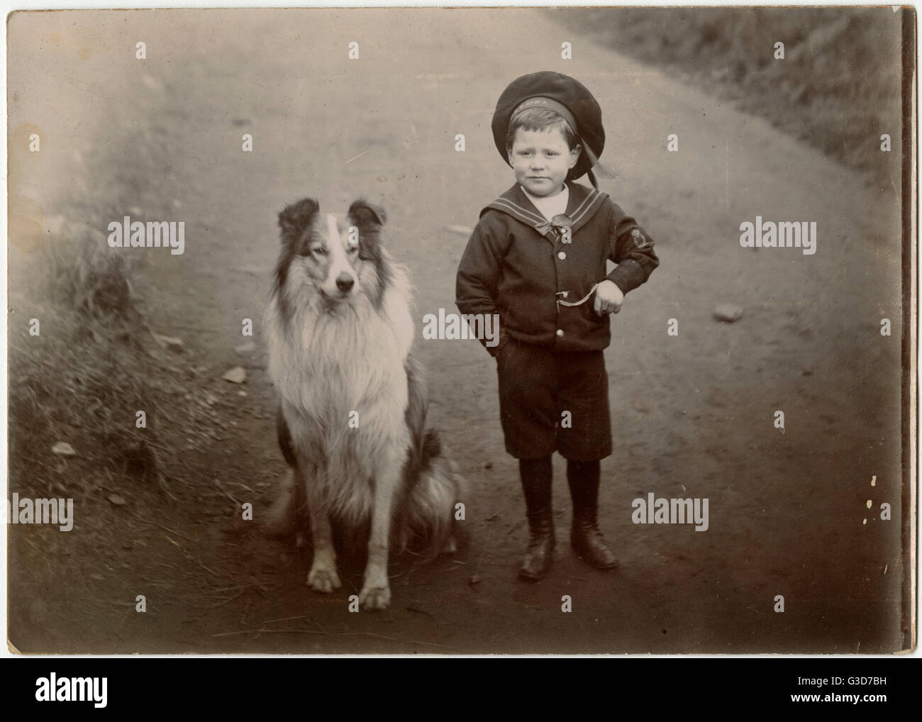 Garçon dans un costume de marin avec un chien de collie Banque D'Images