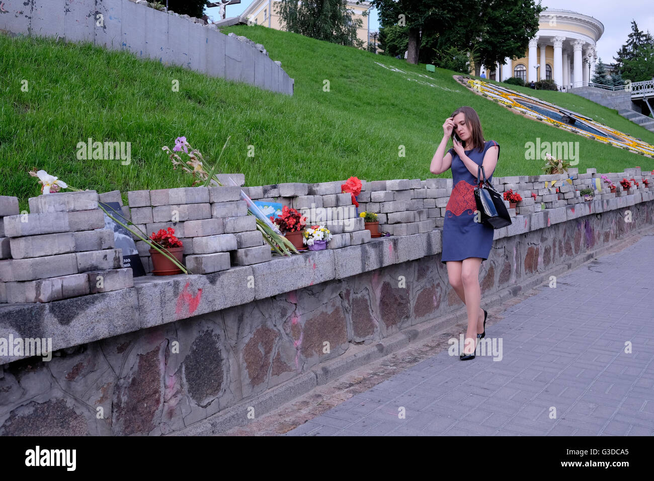 Une femme ukrainienne passe par rangée de fleurs par rangée de fleurs placées dans l'allée des héros tombés Nommé en mémoire de 100 manifestants tués par des tireurs d'élite inconnus lors de la révolution ukrainienne de février 2014 également connue Comme la Révolution Euromaidan ou la Révolution de la dignité dans Maidan Nezalezhnosti ou la place de l'indépendance dans le centre de la capitale de Kiev De l'Ukraine Banque D'Images