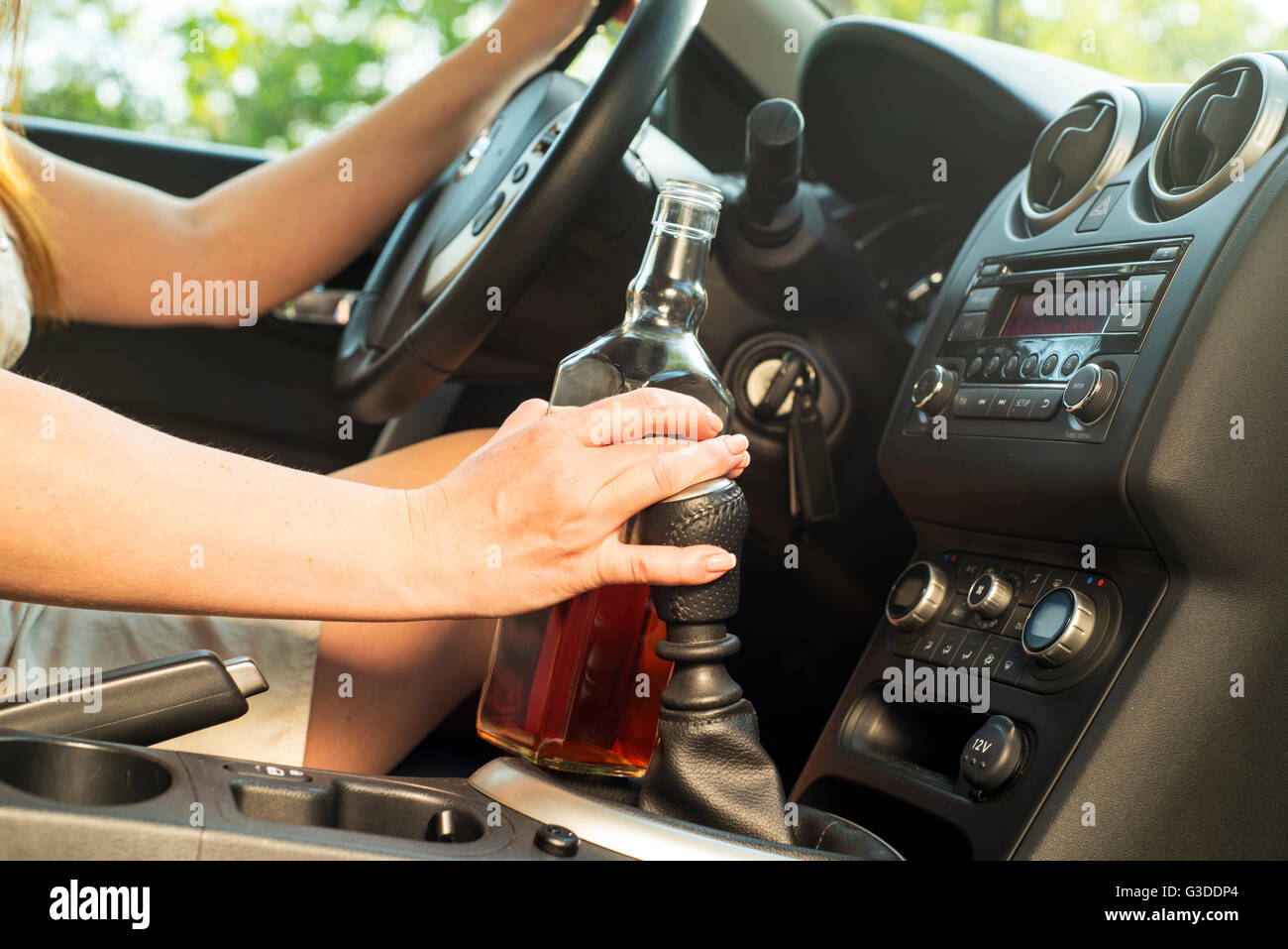 Photo de femme à boire de l'alcool dans la voiture. Banque D'Images