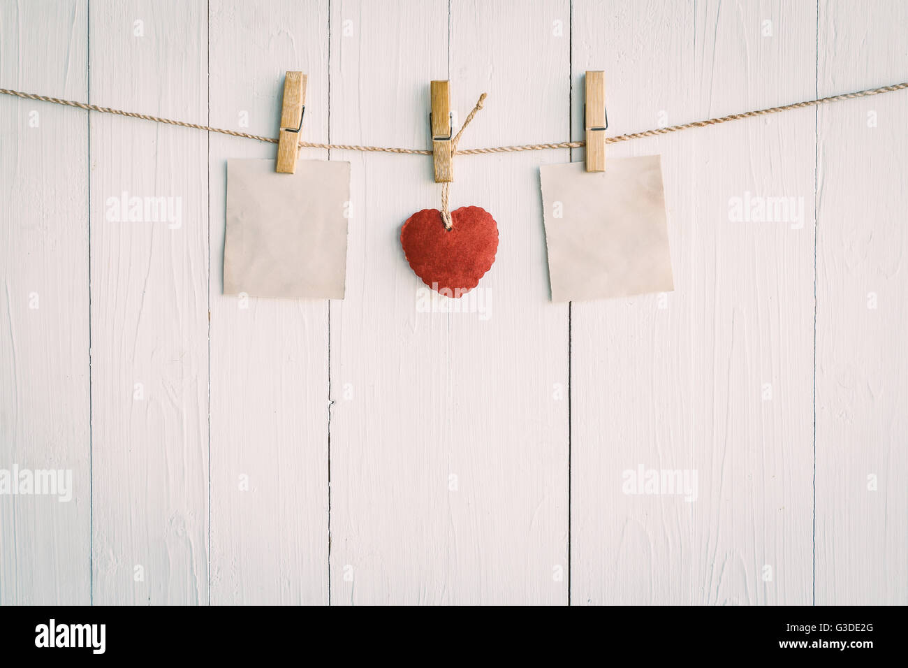 Deux vieux papier vierge et coeur rouge pendaison. Sur fond de bois blanc avec un style vintage. Banque D'Images