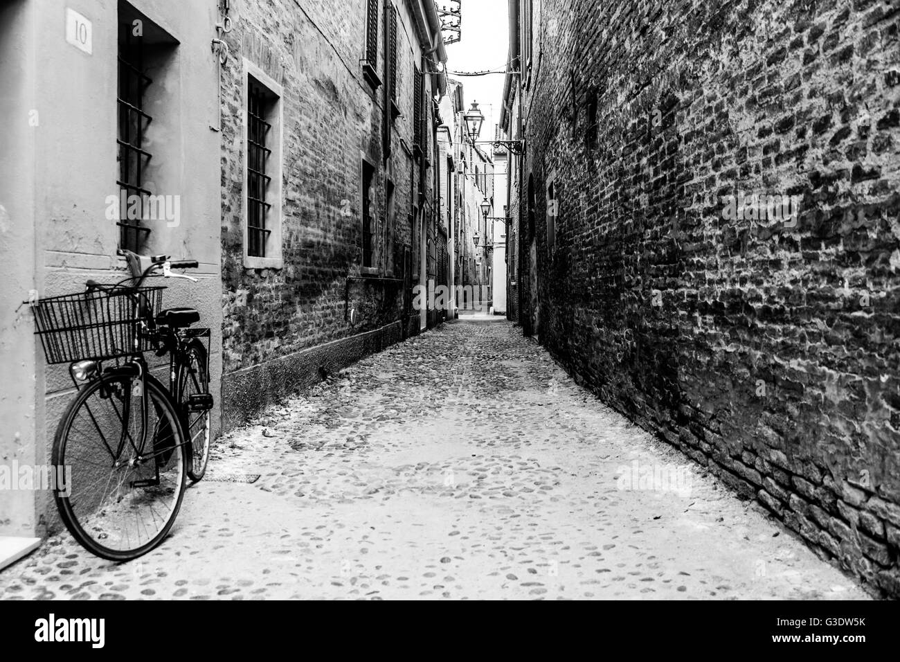 Vélo dans une ruelle vide dans le centre historique de Ferrara, Italie. Banque D'Images