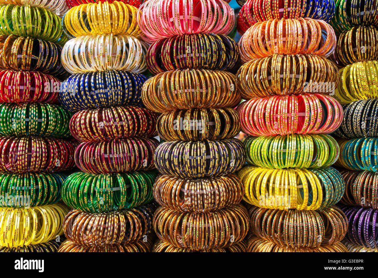 Bracelet bracelets indiens colorés empilés en tas sur l'affichage à un magasin à Jaisalmer, Inde. Banque D'Images