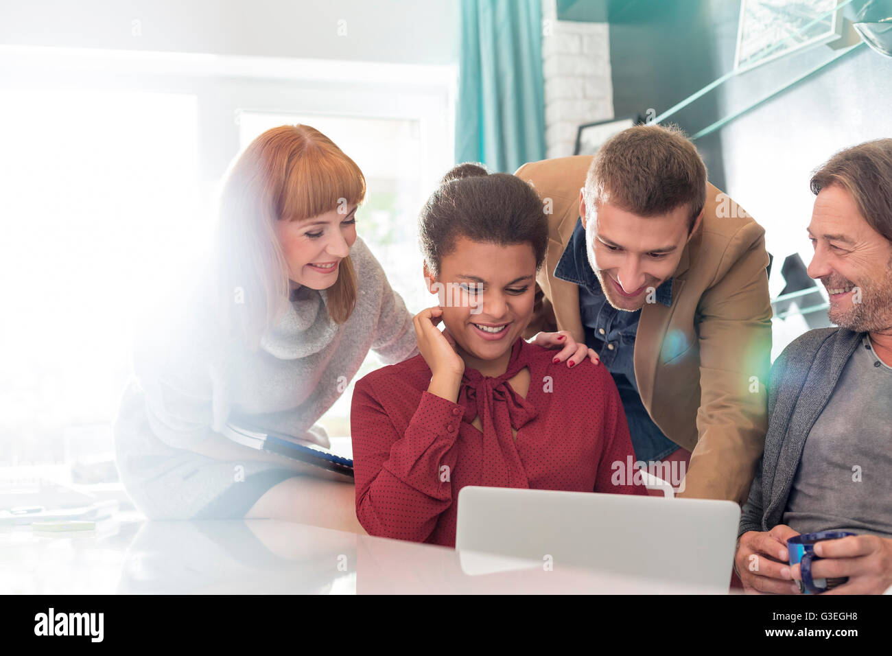 Creative business people sharing laptop in meeting Banque D'Images