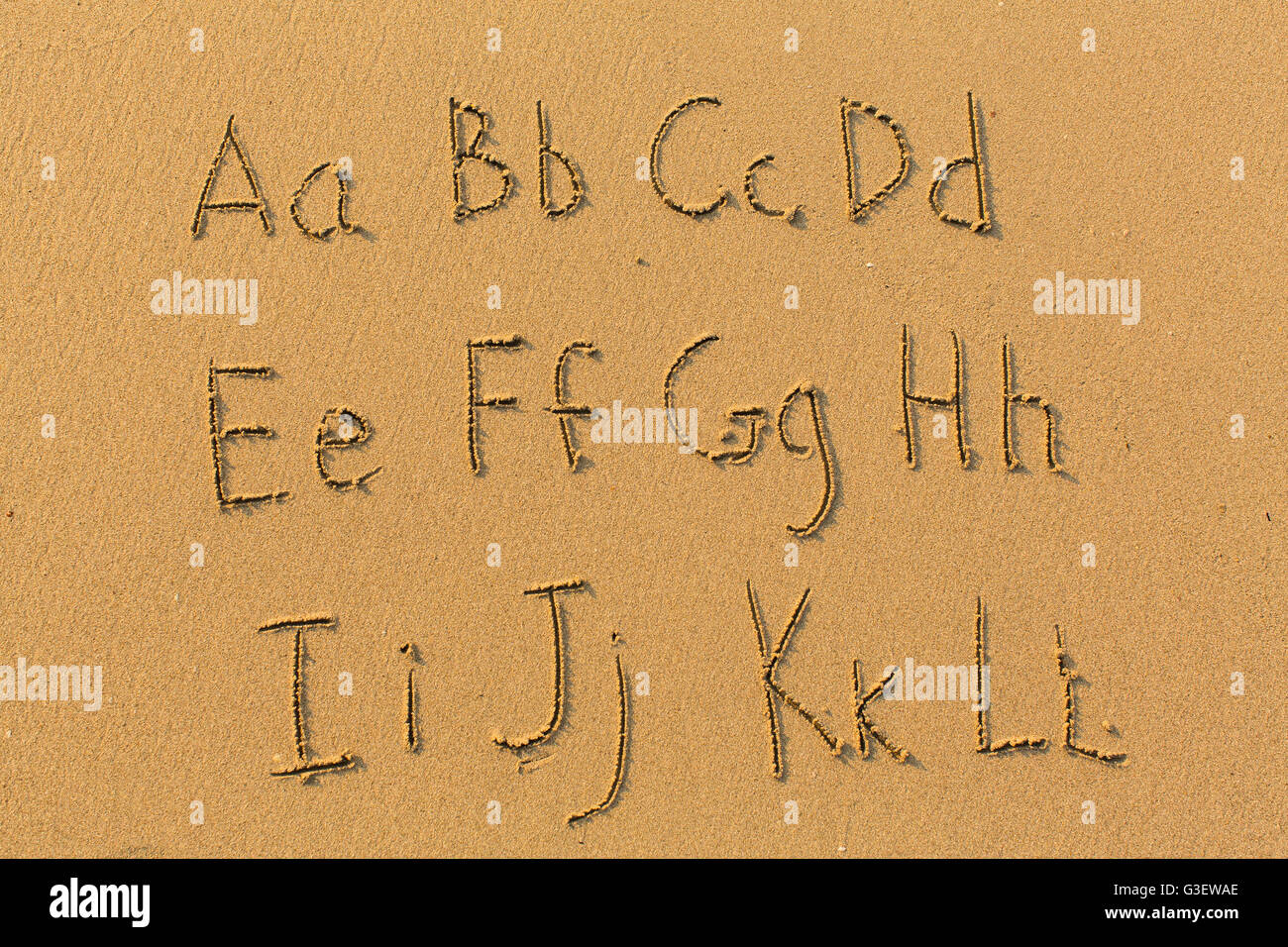 Lettres Alphabet dessiné sur le sable de la plage (A-L, 1/2) Banque D'Images
