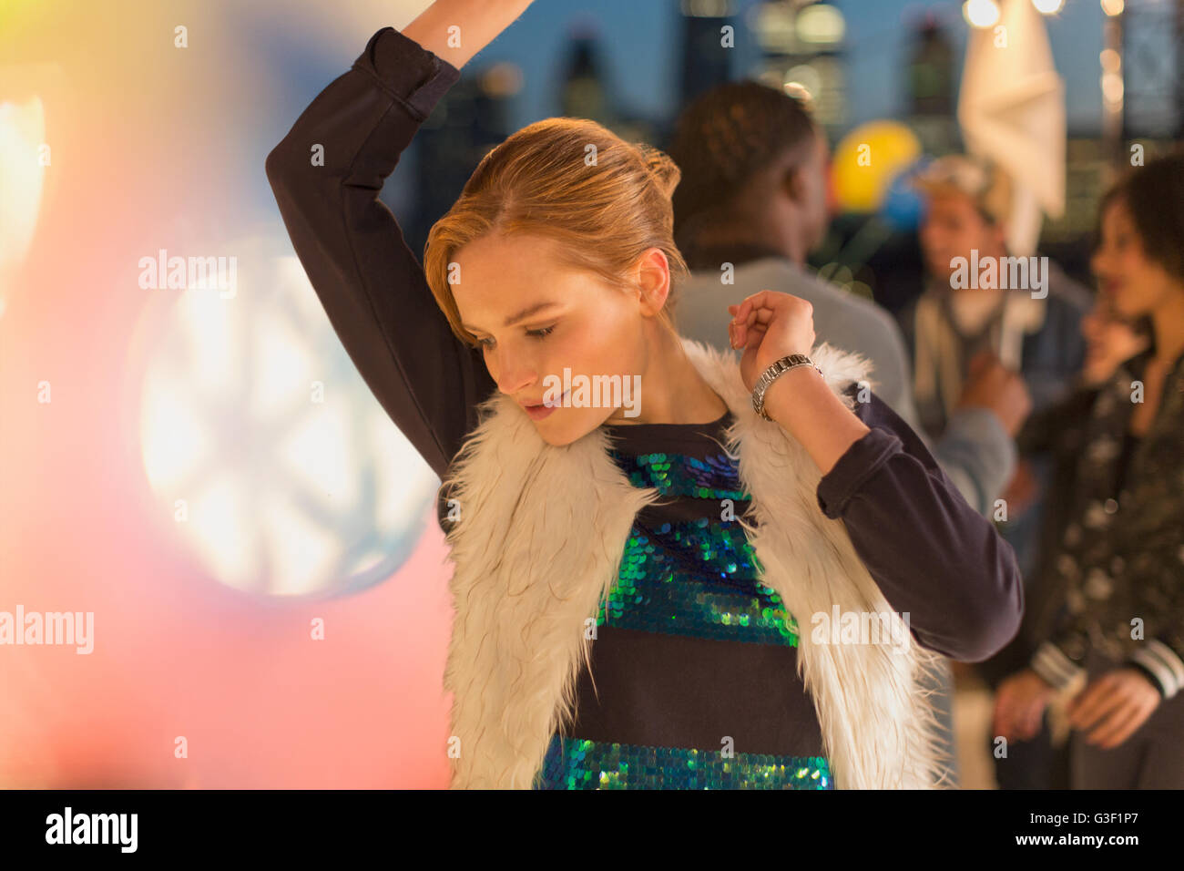 Jeune femme dansant à nuit rooftop party Banque D'Images