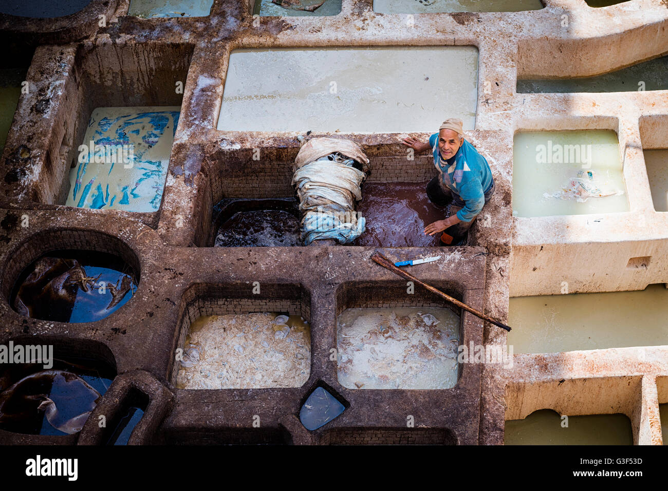 Fes, Maroc - 11 Avril 2016 : un homme travaillant dans une tannerie dans la ville de Fès au Maroc. Banque D'Images