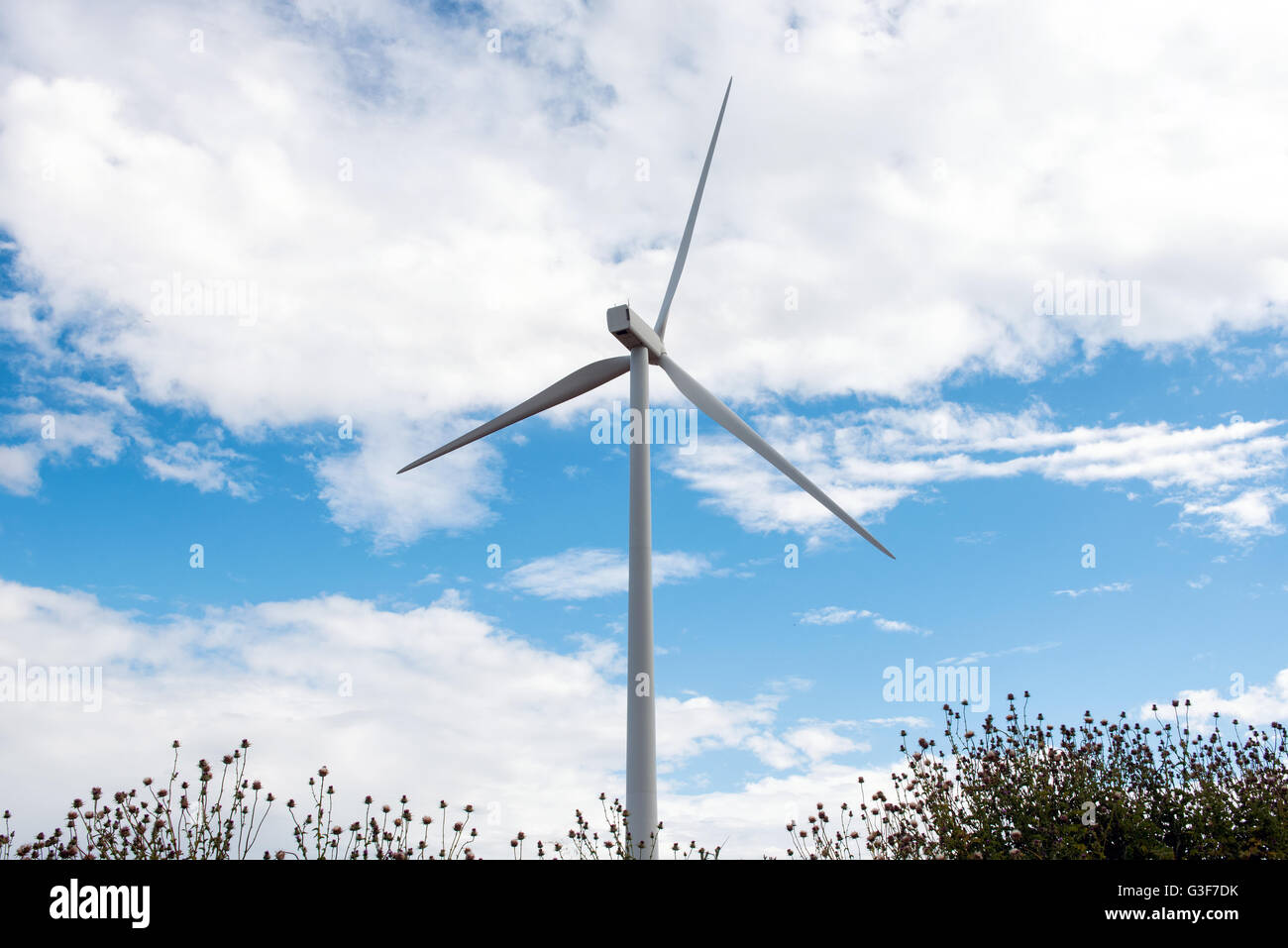 Seule éolienne contre un ciel nuageux ciel bleu dans un concept d'énergie renouvelable et des ressources naturelles Banque D'Images