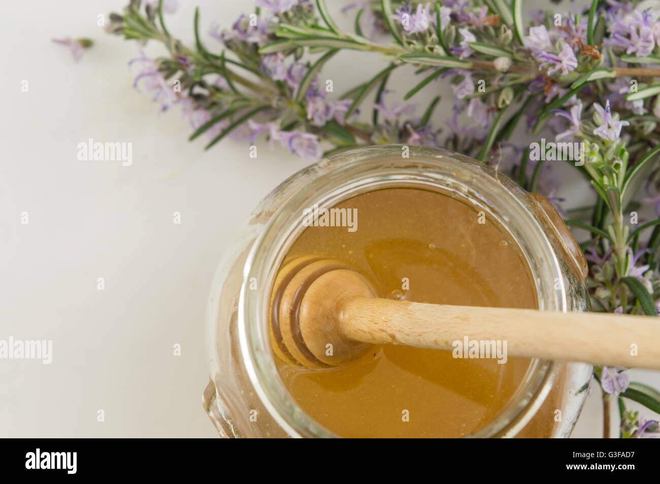Des fleurs fraîches et un pot de miel sucré Banque D'Images