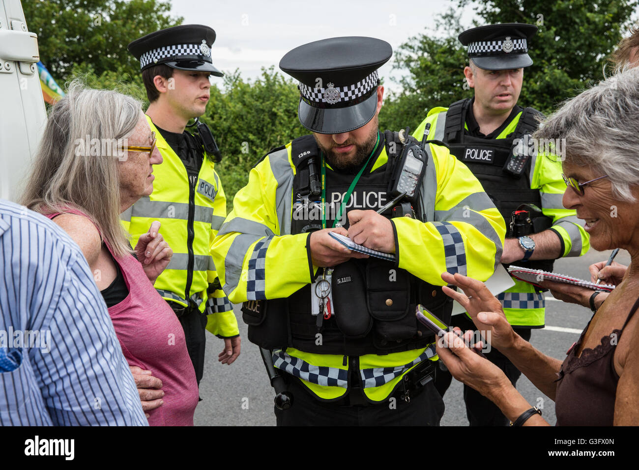 Burghfield, UK. 11 Juin, 2016. Ministère de la Défense mettent en garde les policiers ex-Greenham Common militants de la paix qu'ils recevront des citations pour avoir omis de déposer des banderoles de la clôture périphérique de l'AWE Burghfield en violation alléguée d'un byelaw interdisant de dégradation de la clôture. C'était le cinquième jour consécutif de blocus de l'entrée des livraisons dans le cadre d'un mois d'action contre le renouvellement du Trident à l'extérieur de l'usine responsable de l'assemblage final de Trident monté des têtes nucléaires. Credit : Mark Kerrison/Alamy Live News Banque D'Images