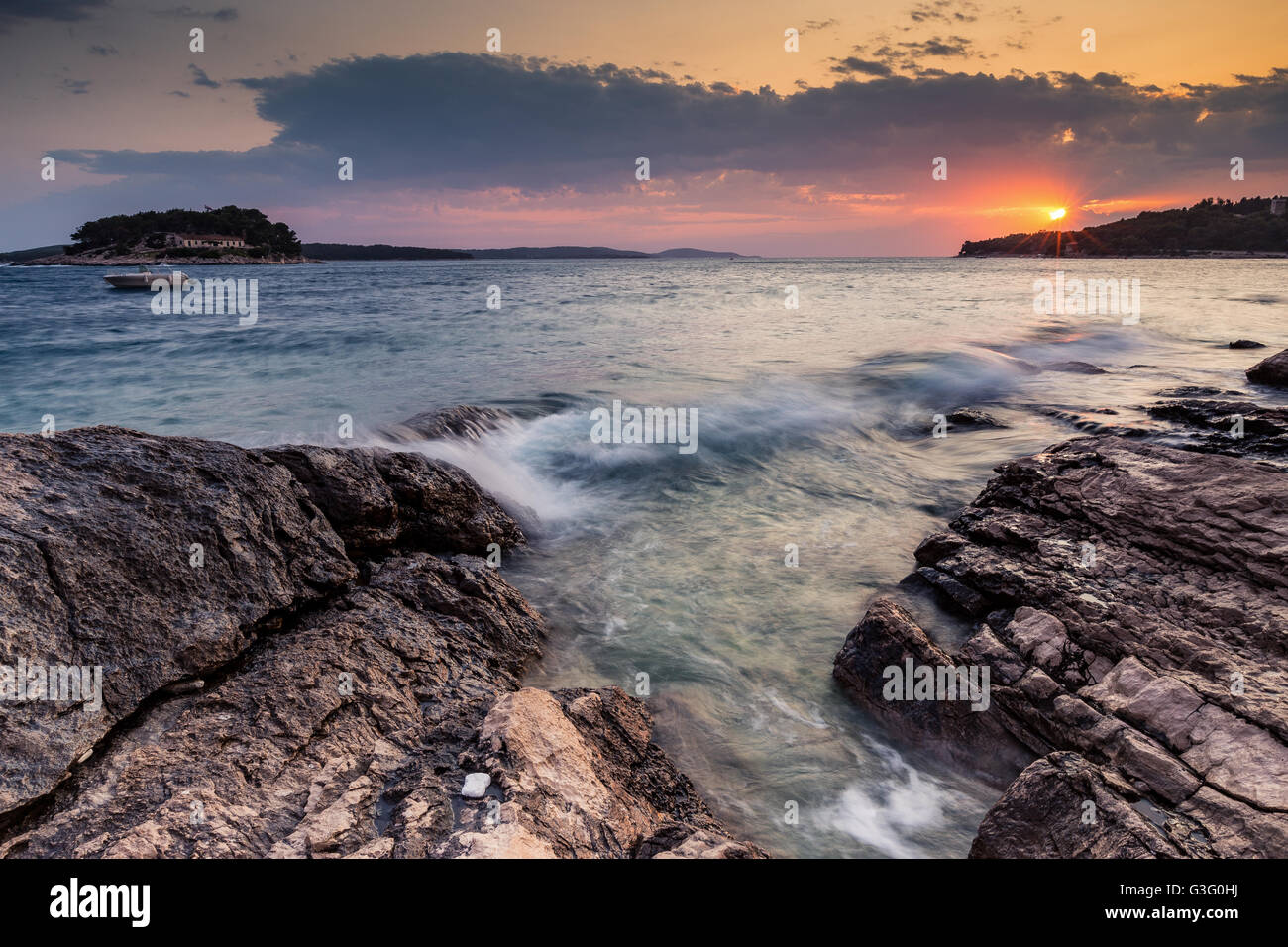 Coucher de soleil sur la côte de Hvar, vague de mer, côte rocheuse. Île de Hvar. Mer Adriatique, Croatie. Europe. Banque D'Images