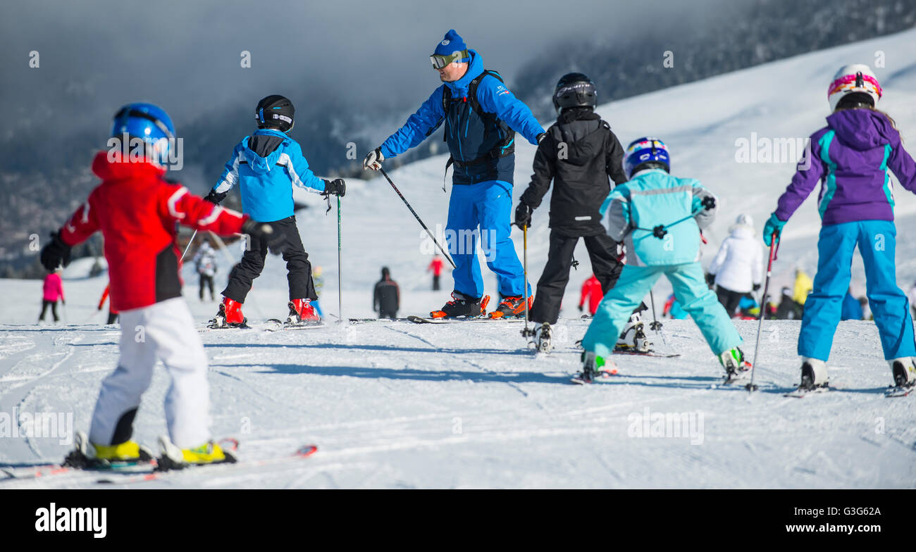 Un moniteur de ski enseigne à un groupe d'enfants dans la station de ski française de Courchevel. Banque D'Images