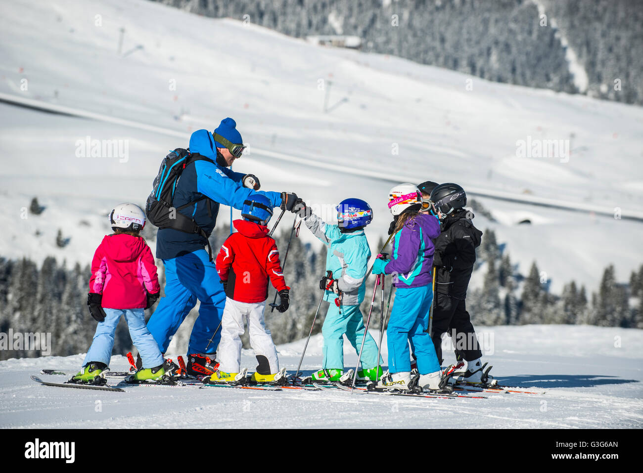 Un moniteur de ski enseigne à un groupe d'enfants dans la station de ski française de Courchevel. Banque D'Images