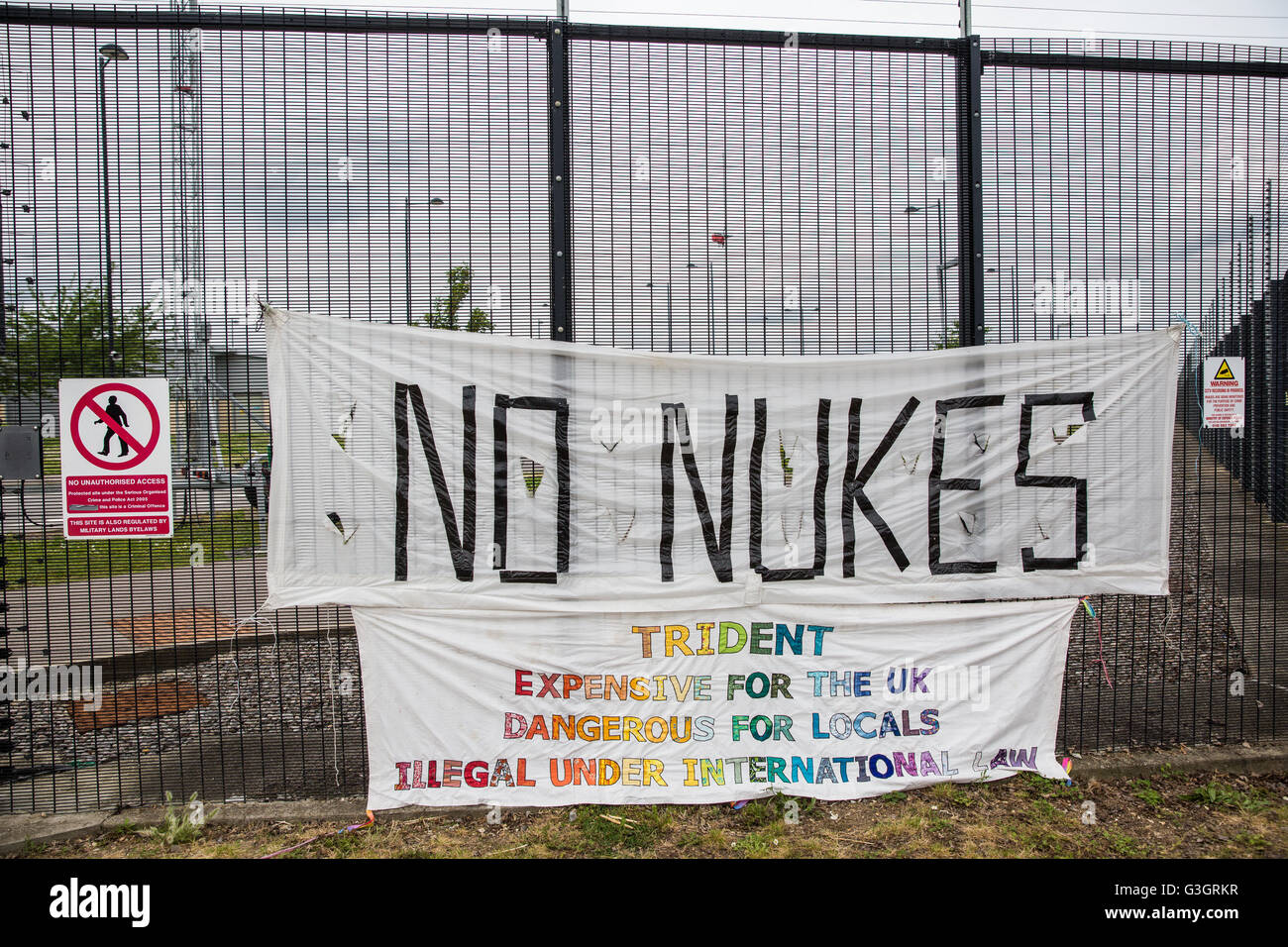 Burghfield, UK. 11 Juin, 2016. Des banderoles accrochées par des ex-militants de la paix commune Greenham sur la clôture de périmètre à AWE Burghfield sur la cinquième journée consécutive de blocus de l'entrée des livraisons dans le cadre d'un mois d'action contre le renouvellement du Trident à l'extérieur de l'usine responsable de l'assemblage final de Trident monté des têtes nucléaires. Credit : Mark Kerrison/Alamy Live News Banque D'Images
