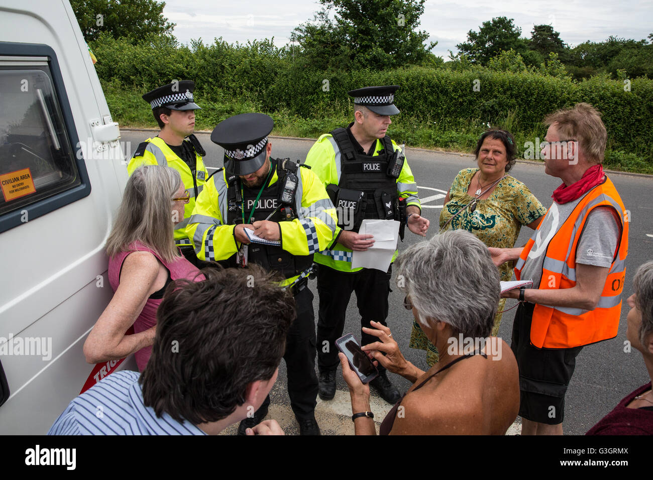 Burghfield, UK. 11 Juin, 2016. Ministère de la Défense mettent en garde les policiers ex-Greenham Common militants de la paix qu'ils recevront des citations pour avoir omis de déposer des banderoles de la clôture périphérique de l'AWE Burghfield en violation alléguée d'un byelaw interdisant de dégradation de la clôture. C'était le cinquième jour consécutif de blocus de l'entrée des livraisons dans le cadre d'un mois d'action contre le renouvellement du Trident à l'extérieur de l'usine responsable de l'assemblage final de Trident monté des têtes nucléaires. Credit : Mark Kerrison/Alamy Live News Banque D'Images