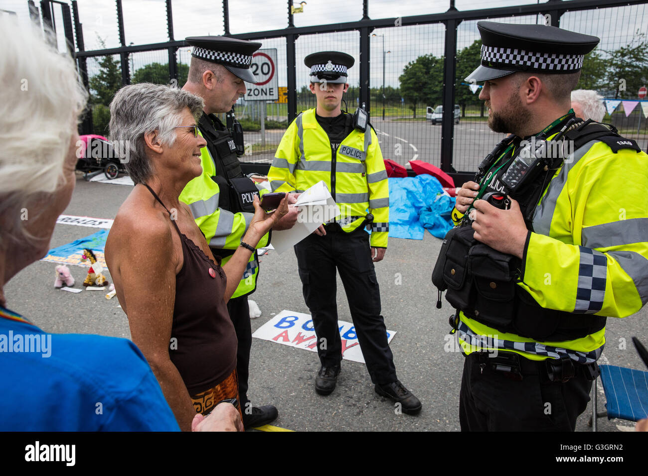 Burghfield, UK. 11 Juin, 2016. Ministère de la Défense mettent en garde les policiers ex-Greenham Common militants de la paix qu'ils recevront des citations pour avoir omis de déposer des banderoles de la clôture périphérique de l'AWE Burghfield en violation alléguée d'un byelaw interdisant de dégradation de la clôture. C'était le cinquième jour consécutif de blocus de l'entrée des livraisons dans le cadre d'un mois d'action contre le renouvellement du Trident à l'extérieur de l'usine responsable de l'assemblage final de Trident monté des têtes nucléaires. Credit : Mark Kerrison/Alamy Live News Banque D'Images