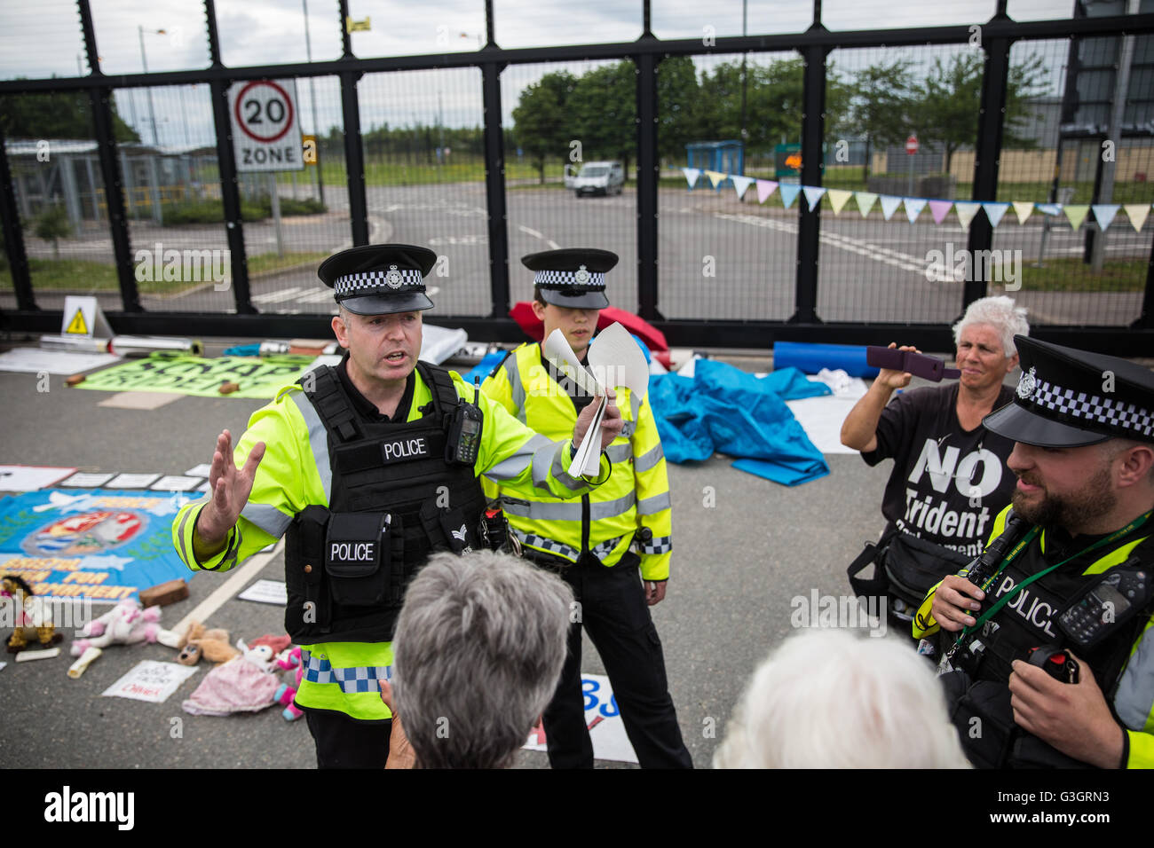 Burghfield, UK. 11 Juin, 2016. Ministère de la Défense mettent en garde les policiers ex-Greenham Common militants de la paix qu'ils recevront des citations pour avoir omis de déposer des banderoles de la clôture périphérique de l'AWE Burghfield en violation alléguée d'un byelaw interdisant de dégradation de la clôture. C'était le cinquième jour consécutif de blocus de l'entrée des livraisons dans le cadre d'un mois d'action contre le renouvellement du Trident à l'extérieur de l'usine responsable de l'assemblage final de Trident monté des têtes nucléaires. Credit : Mark Kerrison/Alamy Live News Banque D'Images