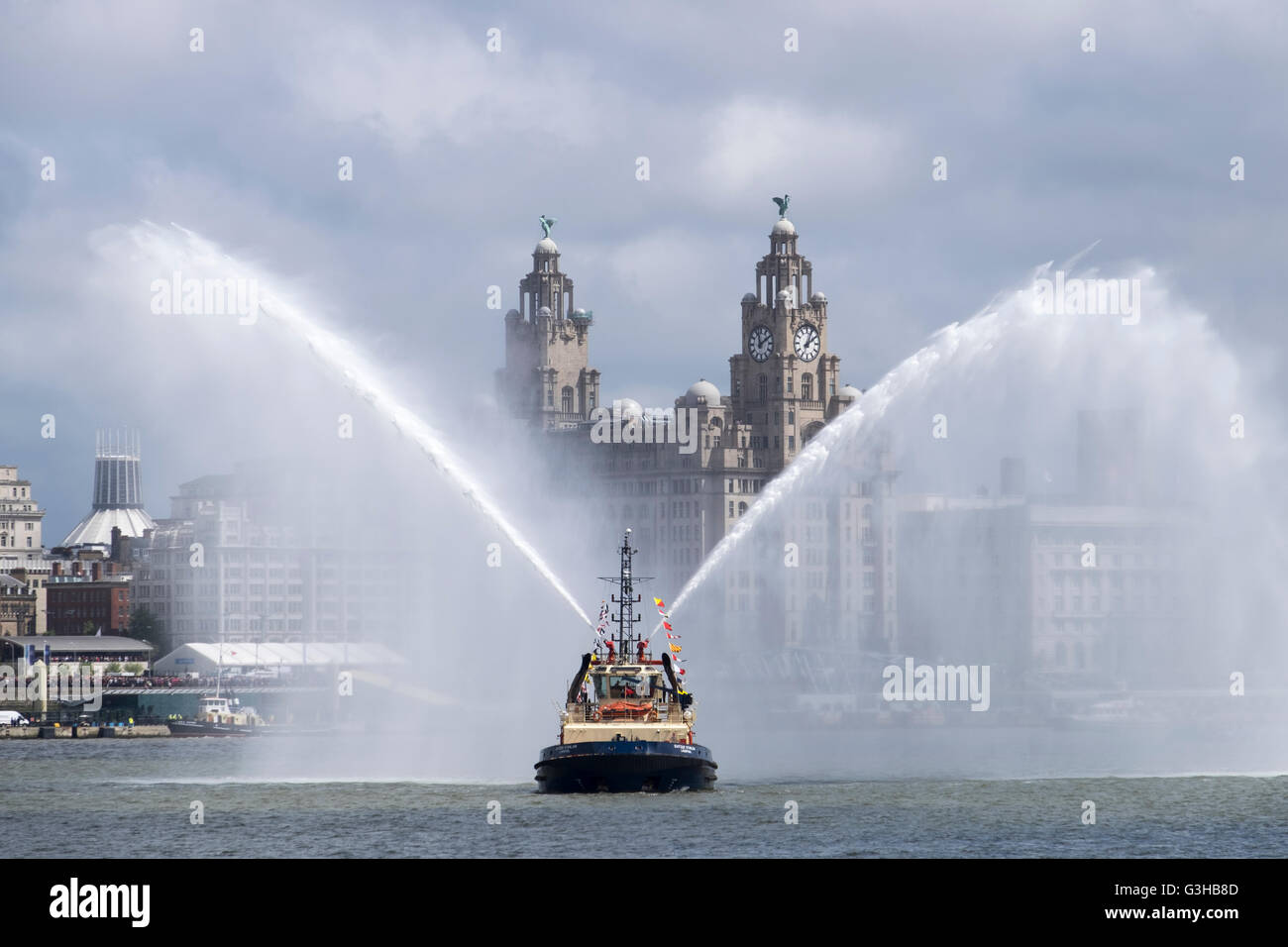 Pulvériser de l'eau bateau-pilote avec le foie bâtiment derrière, Liverpool, Merseyside, Angleterre Banque D'Images