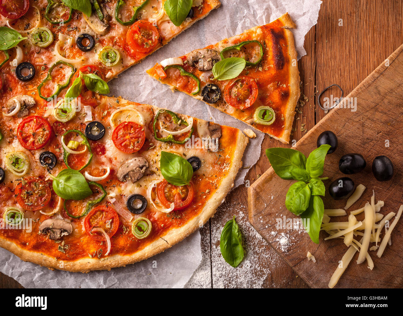 Pizza végétarienne fait maison sur une table en bois. Les ingrédients de la pizza sont des champignons, olives noires, fromage mozzarella Banque D'Images