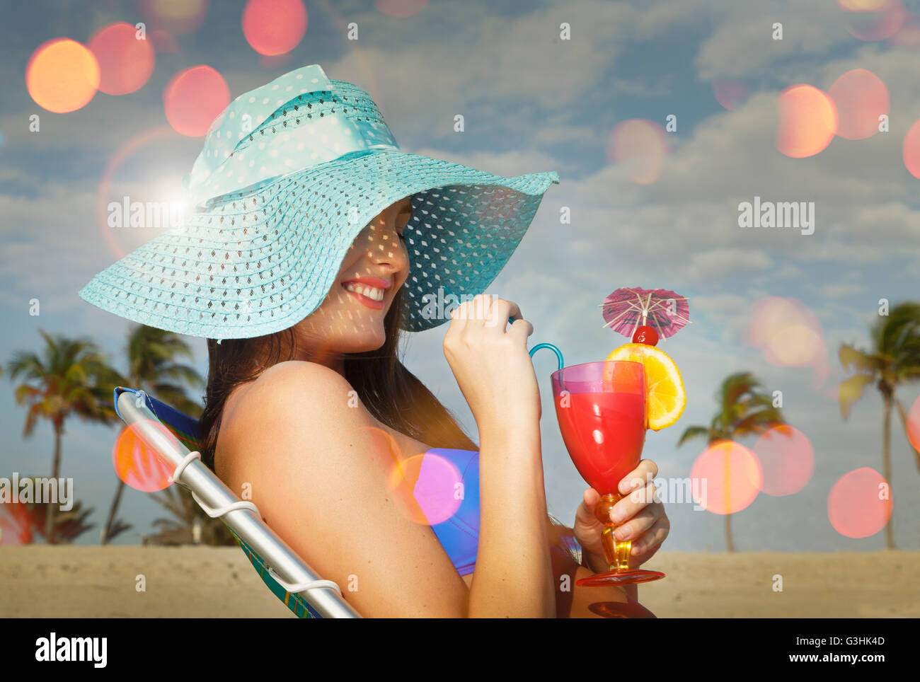 Jeune femme assise sur une chaise longue avec un cocktail au Miami Beach, Floride, USA Banque D'Images