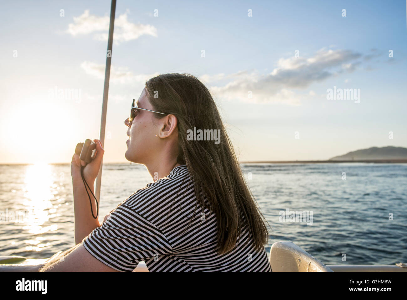 Young woman photographing coucher de bateau d'estuaire, Tamarindo, Guanacaste, Costa Rica Banque D'Images