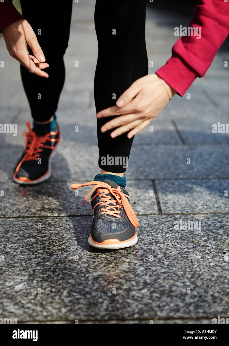 Jambes de femme portant des chaussures de course sur le pavé Banque D'Images
