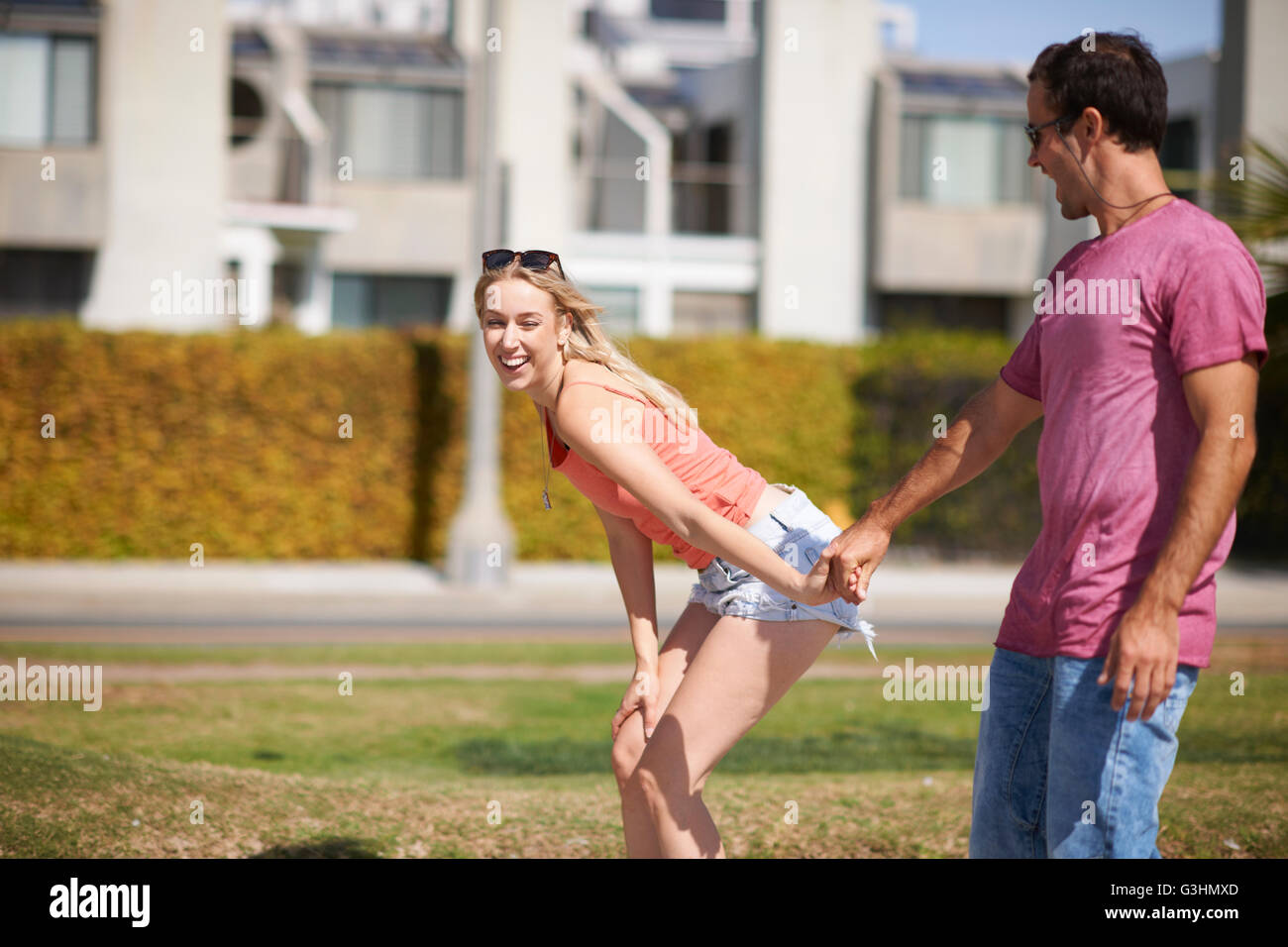 Couple de jouer à l'extérieur, tenant les mains, rire Banque D'Images