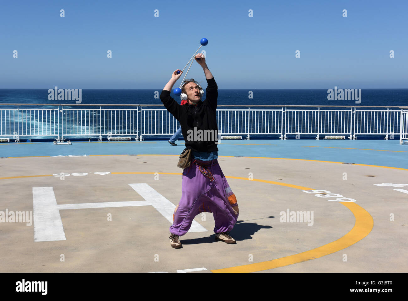Man juggling sur le pont de la Brittany Ferries MV Pont-Aven cruiseferry naviguant entre Portsmouth et Santander. Banque D'Images