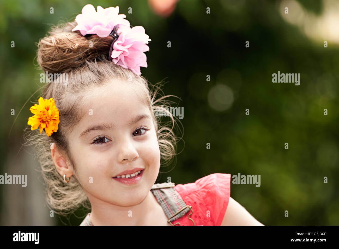 Portrait of smiling little girl avec des fleurs dans les cheveux Banque D'Images