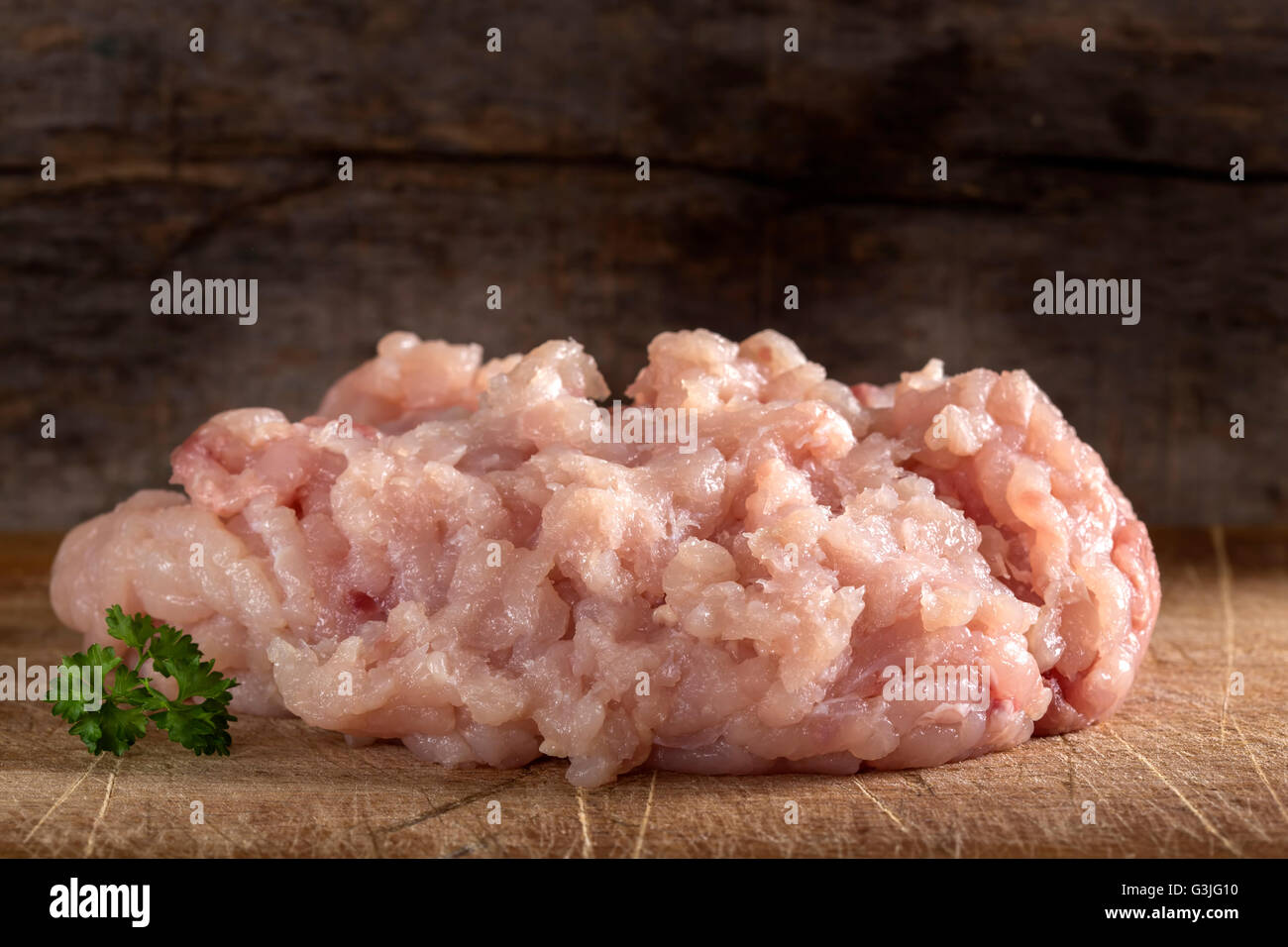 La viande hachée poulet frais sur fond de bois de persil Banque D'Images