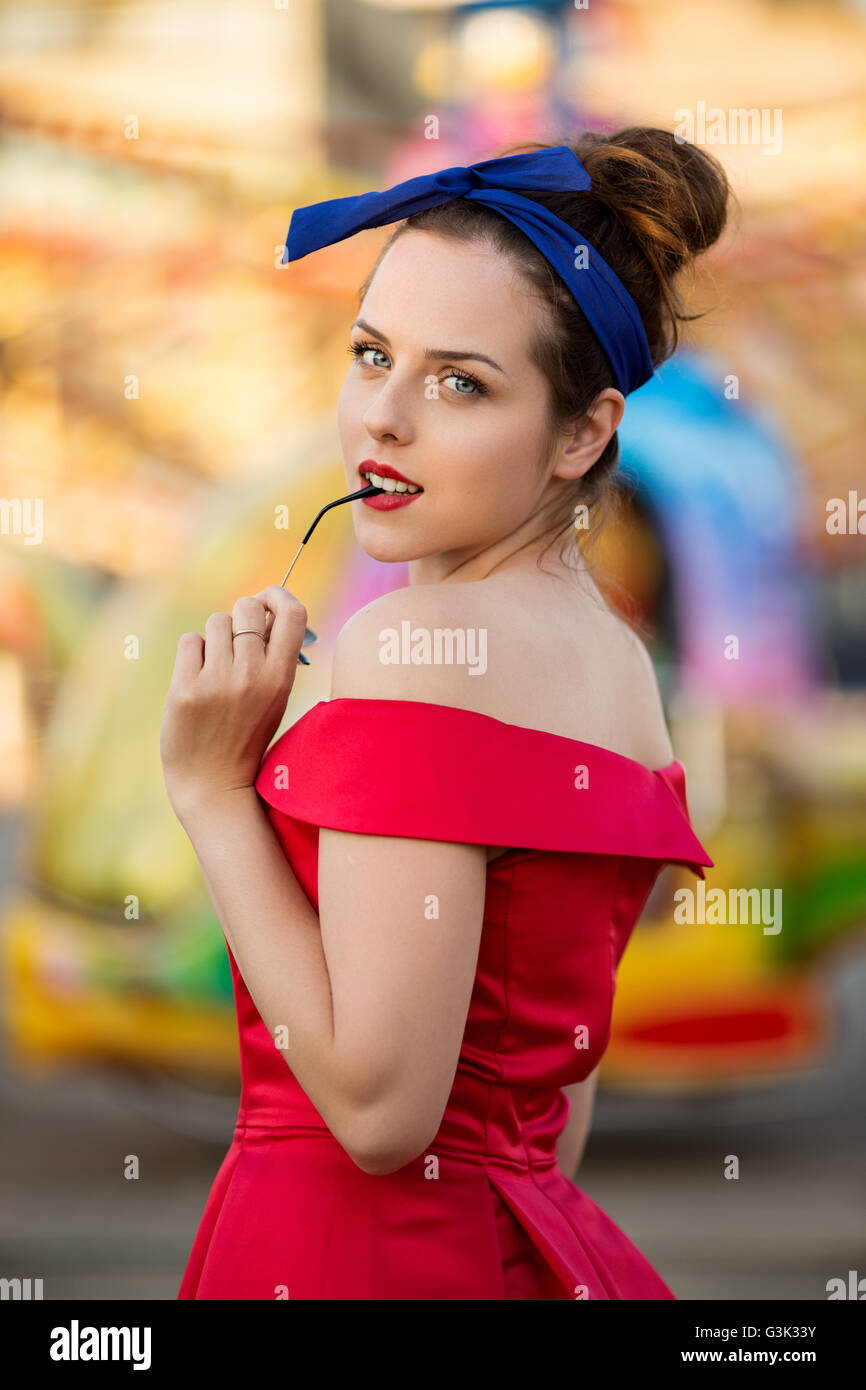 Portrait of a young woman wearing red dress à Luna park Banque D'Images