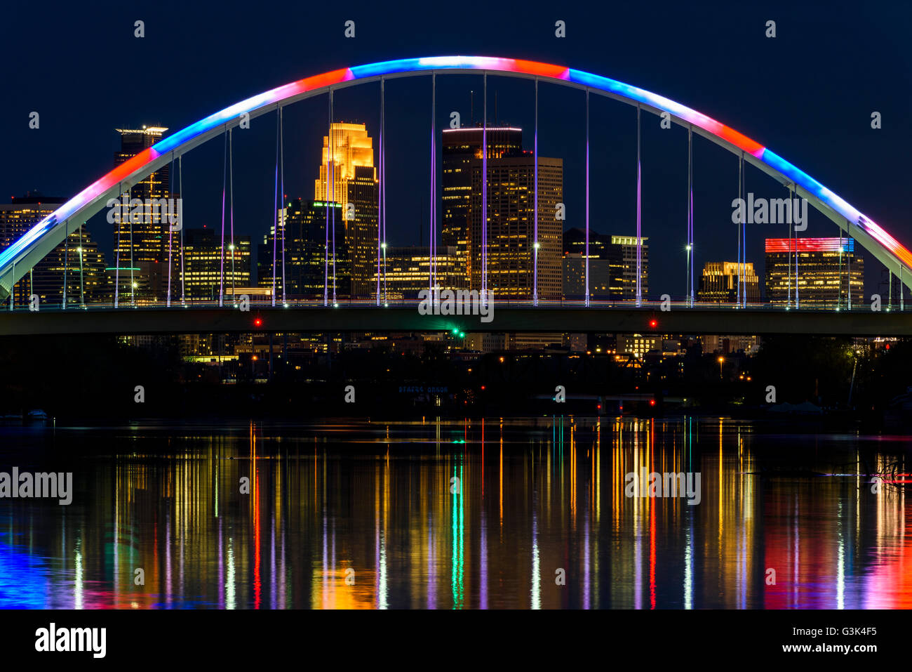 Minneapolis Minnesota skyline vue à travers le pont de l'Avenue Lowry au crépuscule avec l'éclairage bleu et rouge. Banque D'Images