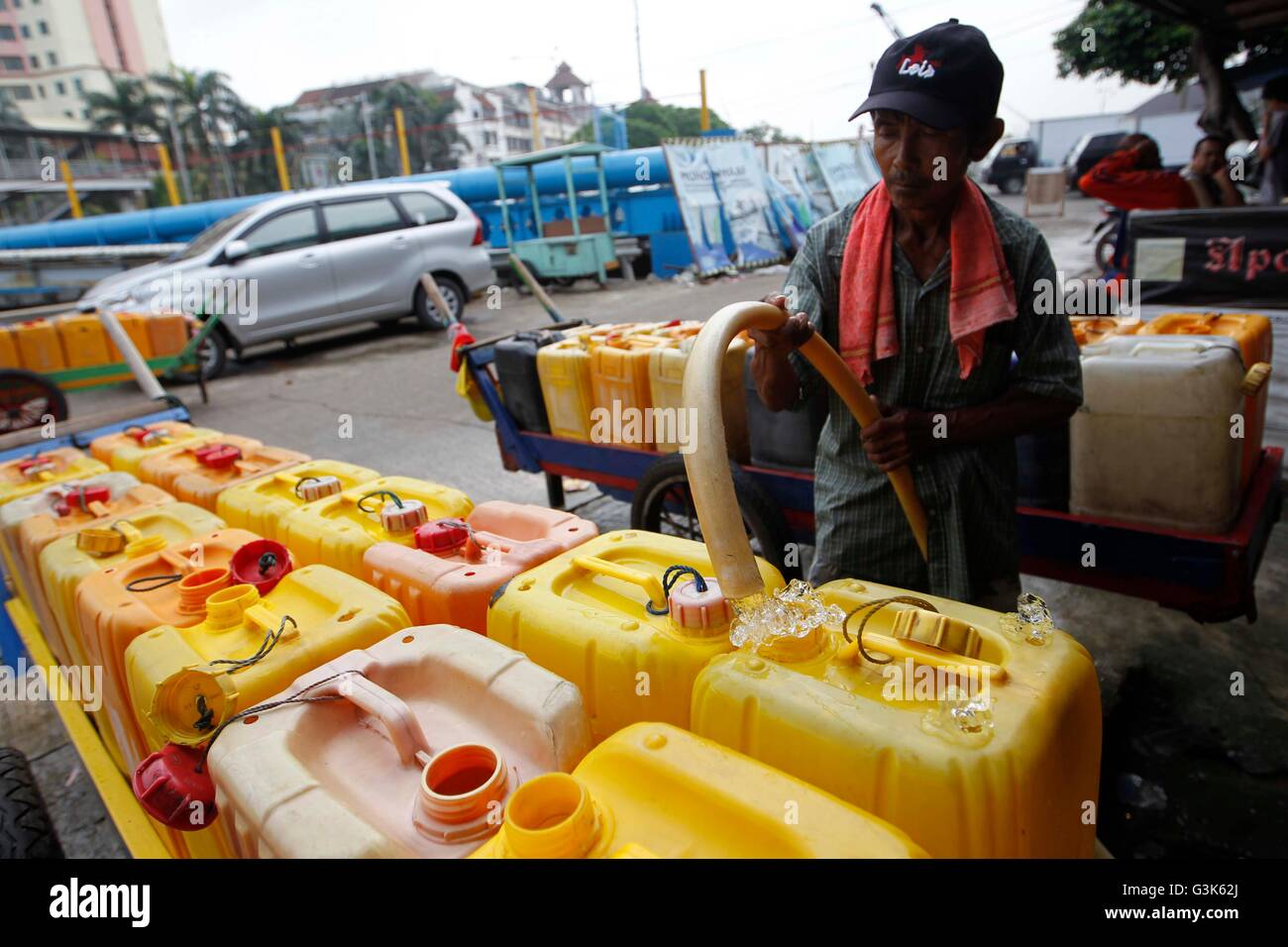 Un homme remplir l'eau dans des récipients en plastique à une station de pompage avant livraison de vendre aux résident à bidonville. Autour de 230 millions de personnes en Indonésie sont sous les risques pour la santé découlant de la contamination de l'eau qui sont parmi les plus élevés dans les pays d'Asie du Sud-Est. Les pénuries d'eau sera le problème le plus urgent dans la prochaine décennie, aggravée par l'accroissement de la population mondiale, le changement climatique devrait perturber la configuration des pluies, ce qui conduit à plus de graves sécheresses et inondations, qui posent des problèmes pour la fourniture d'eau douce. (Photo par Andrew Garry/Lotulung Pacific Press) Banque D'Images