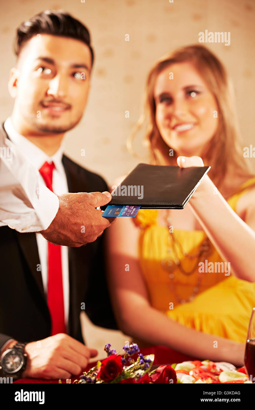 3 personnes des couples mariés, l'étranger et l'offre d'hôtel dîner factures donnant Banque D'Images