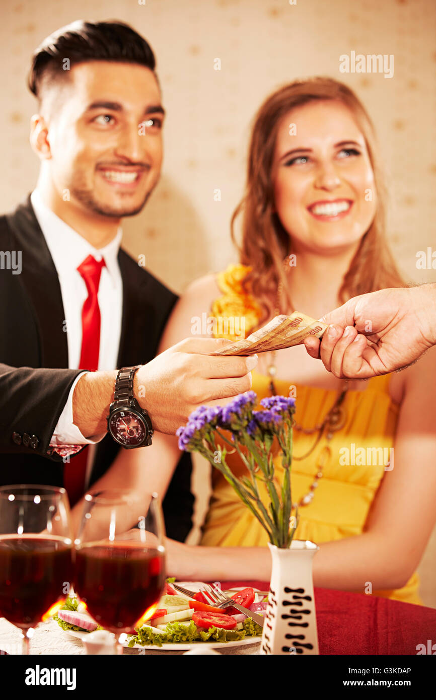 3 personnes des couples mariés, l'étranger et l'offre d'hôtel dîner factures donnant Banque D'Images