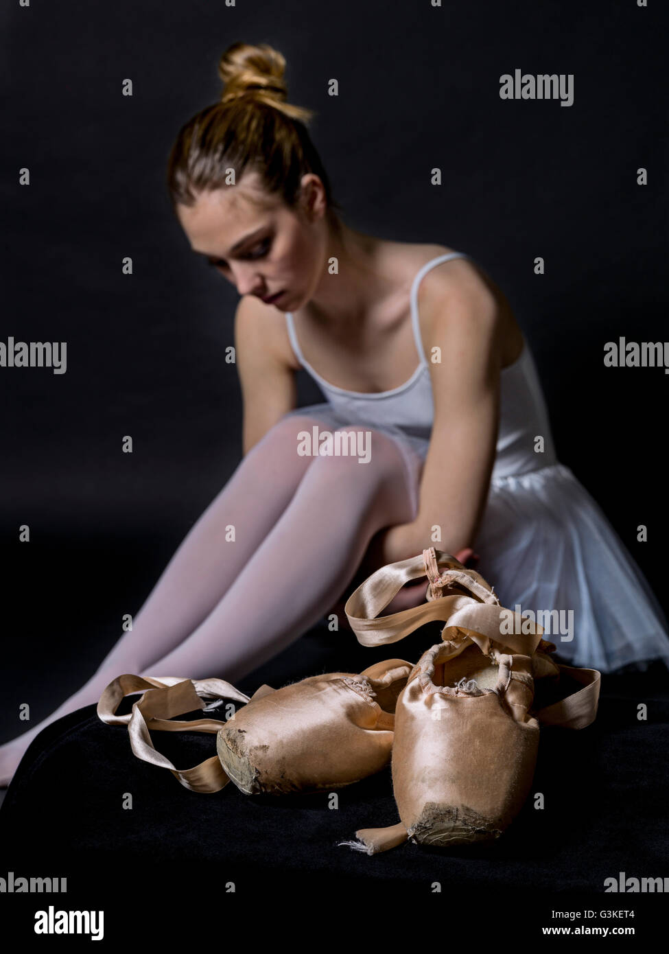 Close-up d'un ballet pointes, et dans l'arrière-plan une danseuse au repos, assis sur fond noir Banque D'Images