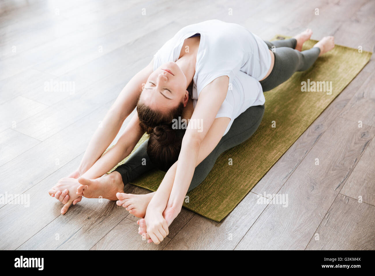 Deux jeunes femmes détendue des étirements et de la pratique du yoga en studio Banque D'Images