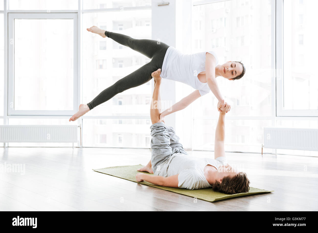 Attractive Woman Stretching et yoga acro faire avec partenaire en studio Banque D'Images