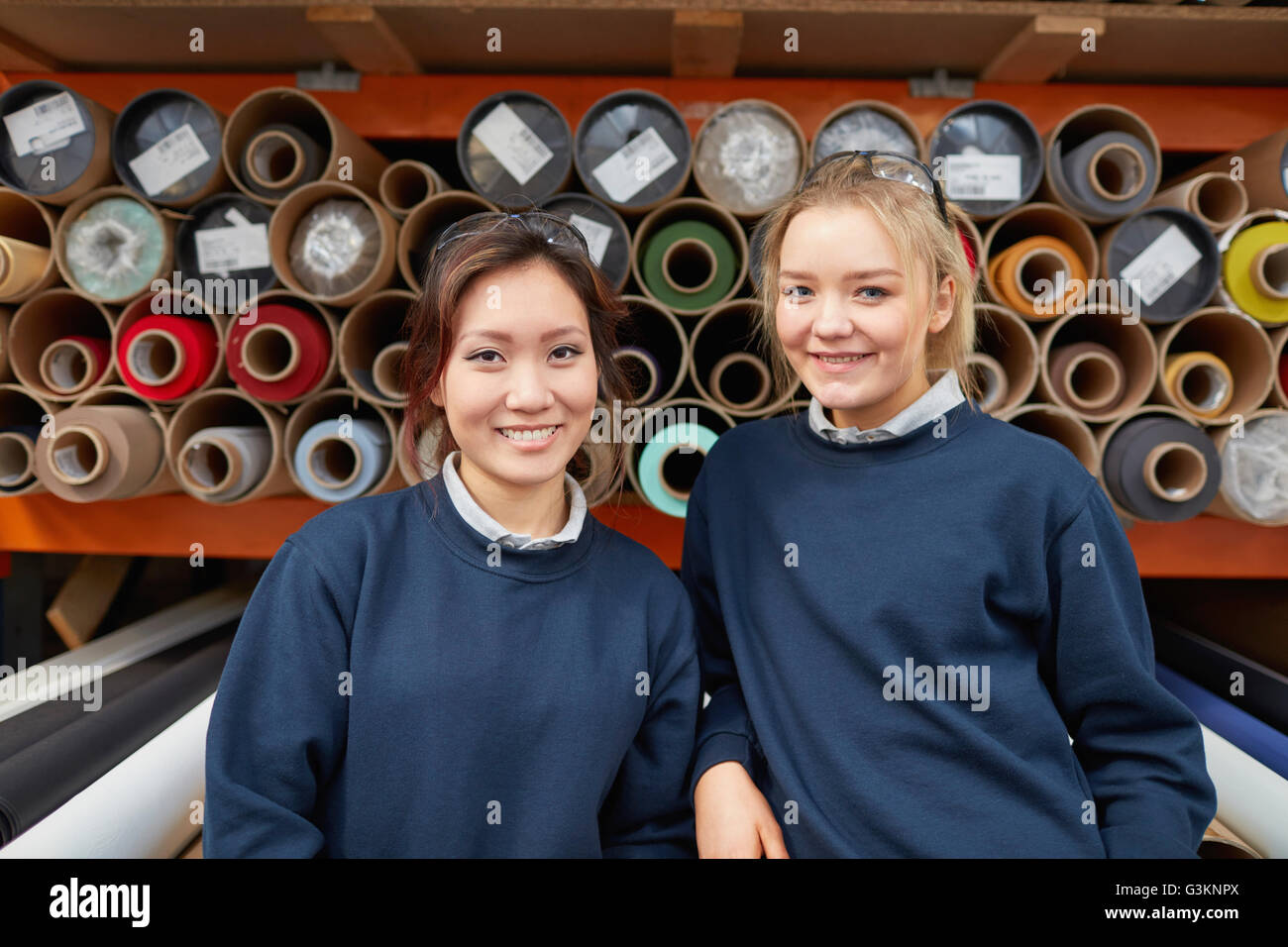 Portrait de deux femmes, les ouvriers d'usine en face de rouleaux textiles en usine pour rouleau Banque D'Images