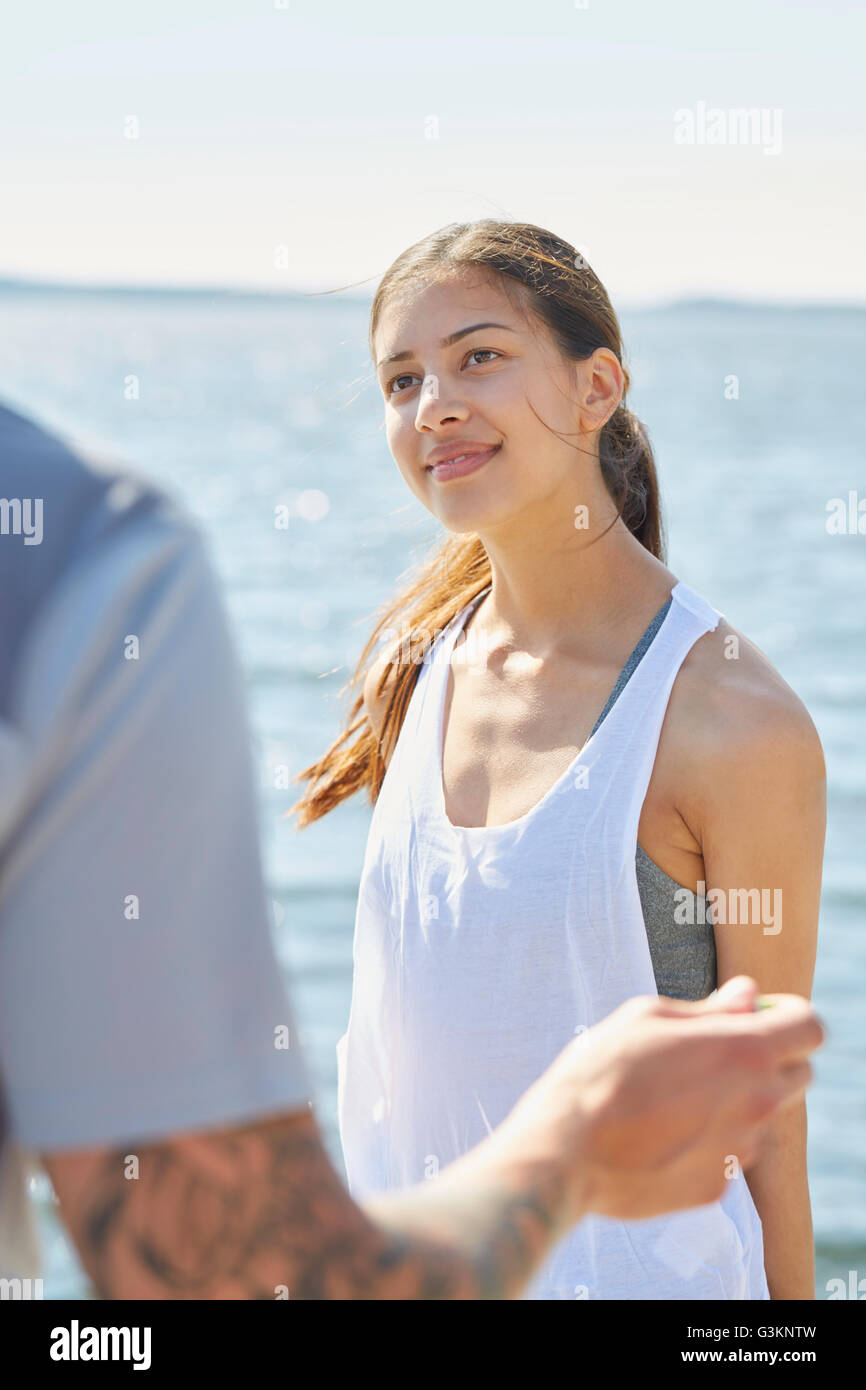Femme en face de l'ocean à la recherche à l'ami smiling Banque D'Images