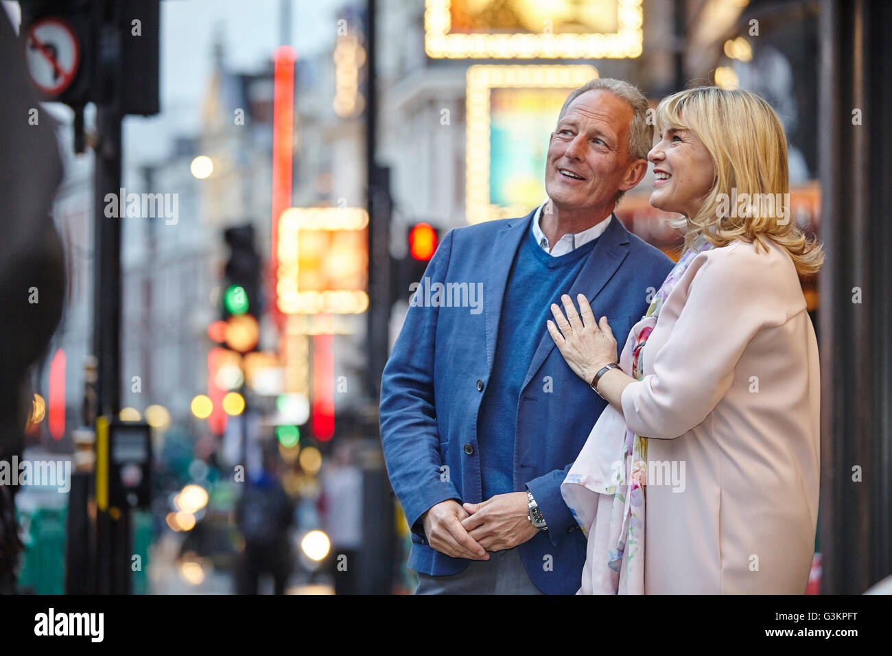 Couple mature dating jusqu'à la rue de la ville au crépuscule, London, UK Banque D'Images