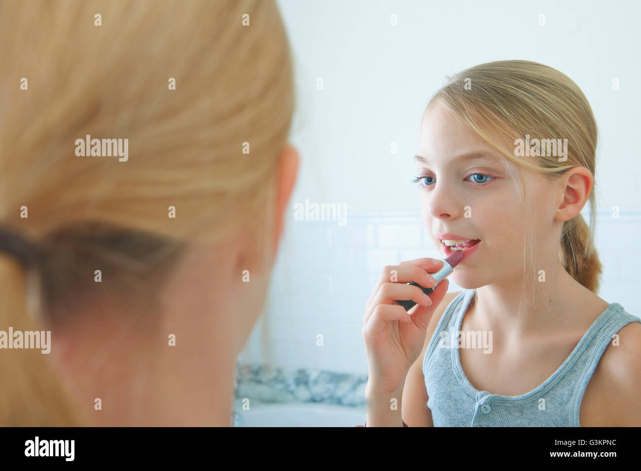 Au-dessus de l'épaule image miroir de girl applying lipstick Banque D'Images