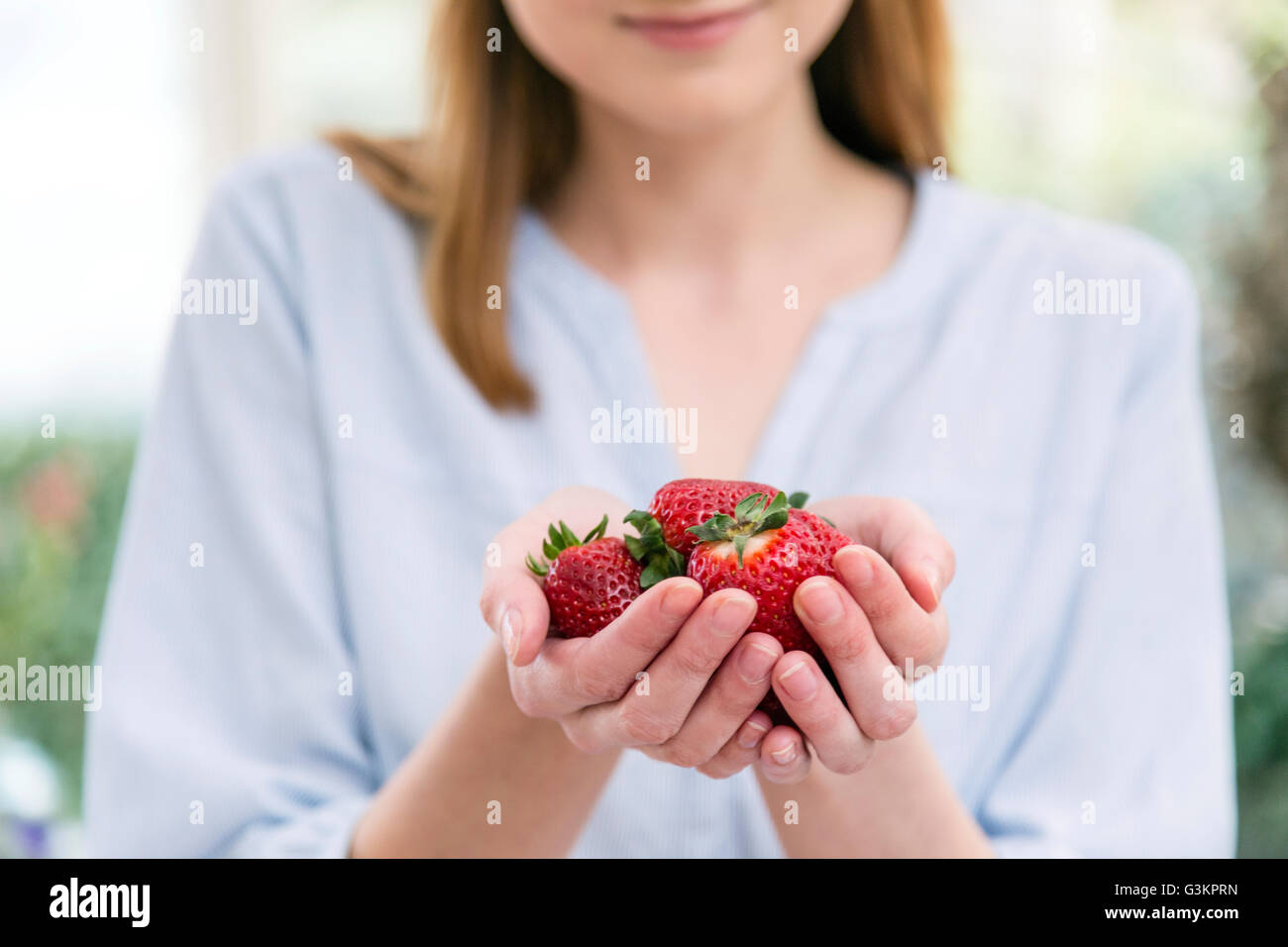 Woman with hands holding bombée fraises Banque D'Images