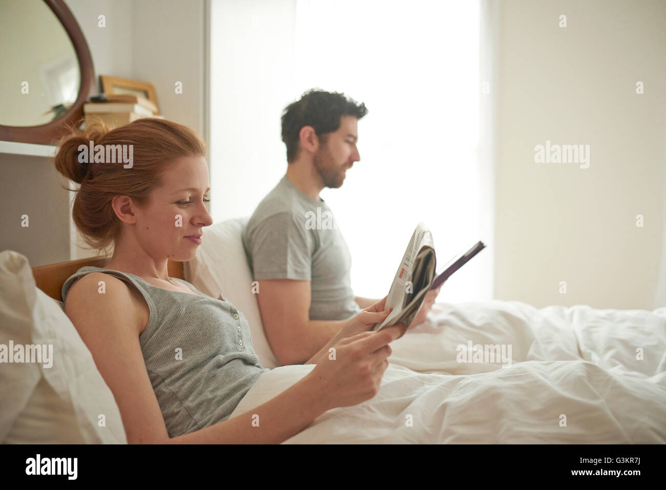 Couple lecture tablette numérique grand format et au lit Banque D'Images