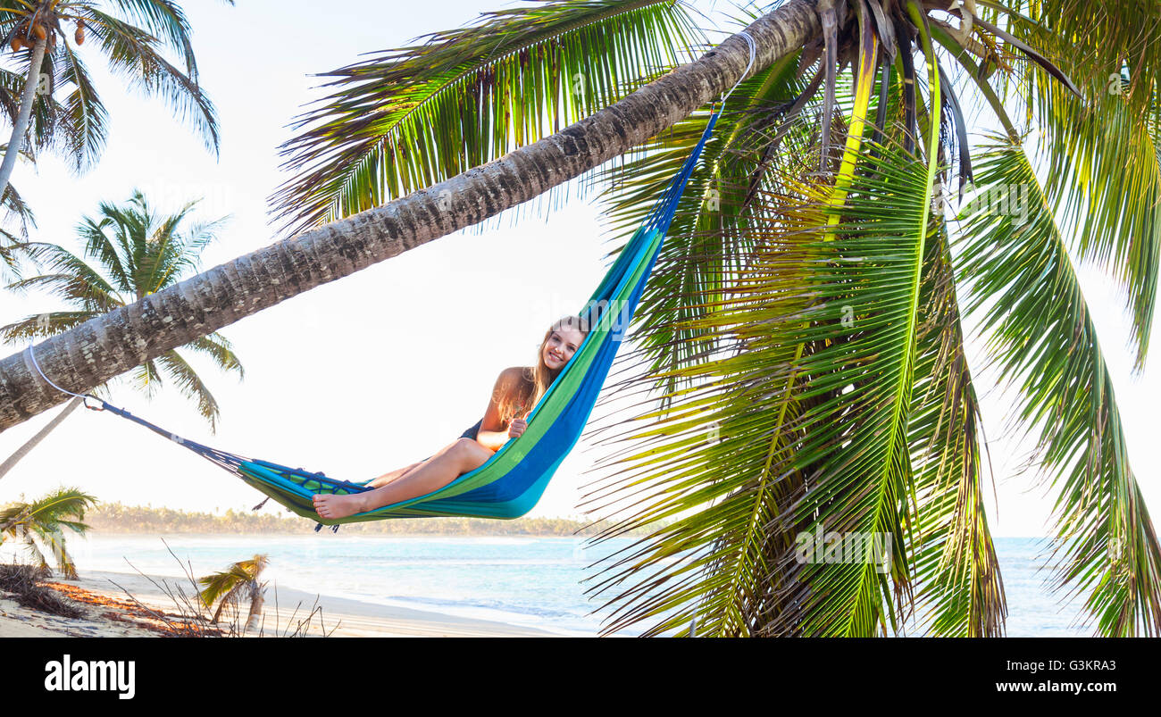 Portrait of young woman reclining in palm tree hammock beach, la République dominicaine, les Caraïbes Banque D'Images