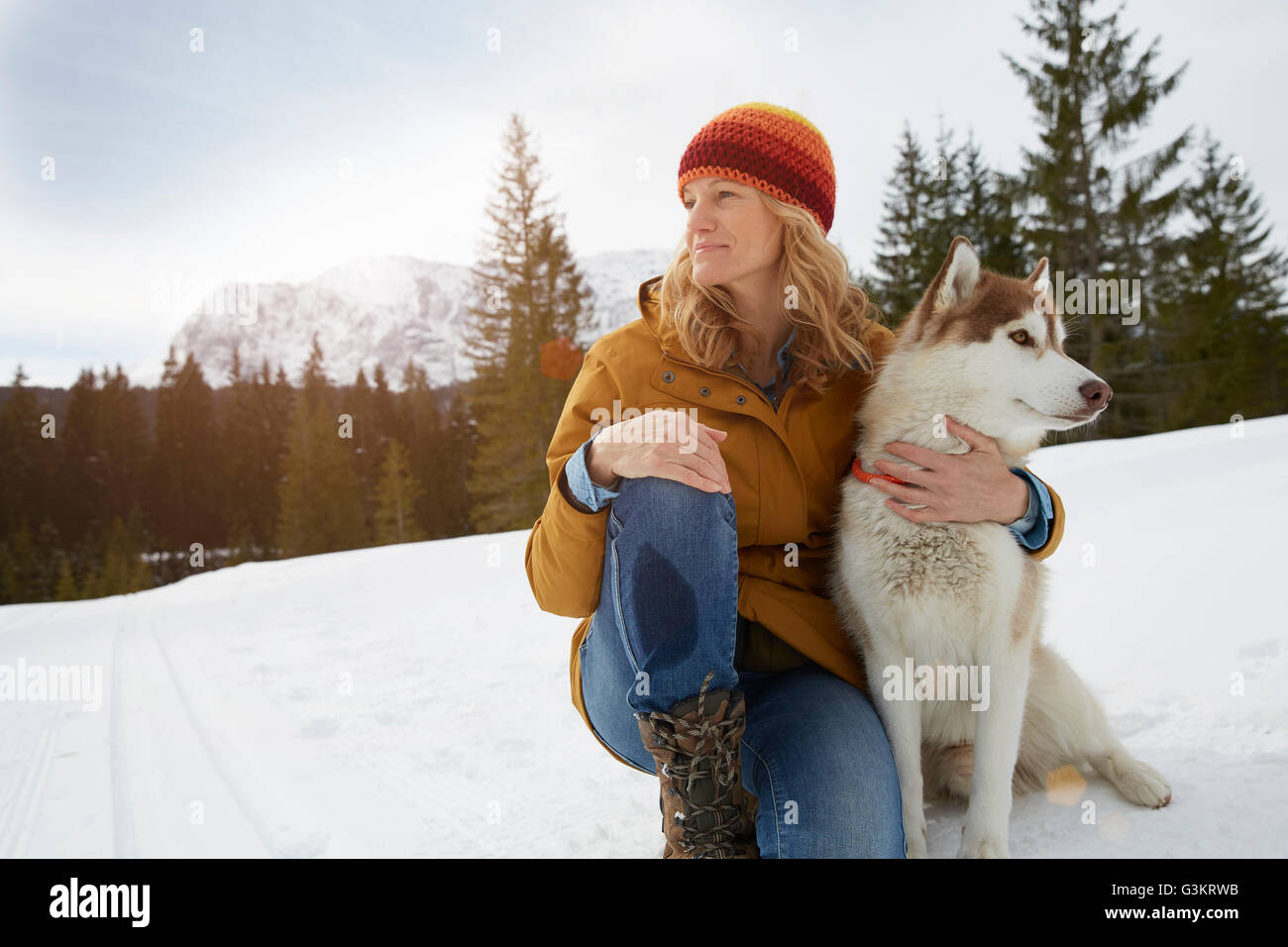 Femme assise avec husky dans la neige paysage, Elmau, Bavière, Allemagne Banque D'Images