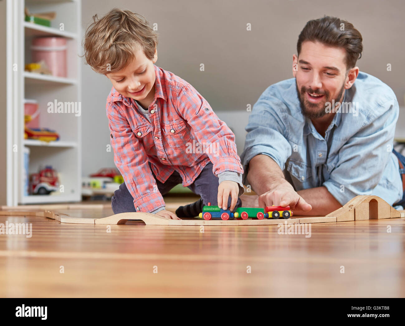 Père et fils jouant avec train jouet en bois Banque D'Images