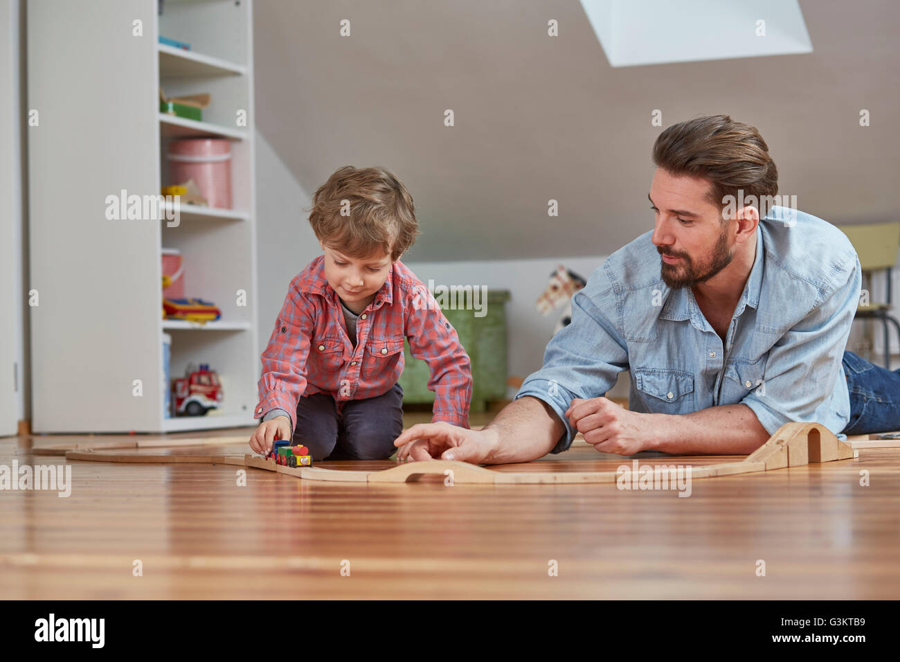 Père et fils jouant avec train jouet en bois Banque D'Images