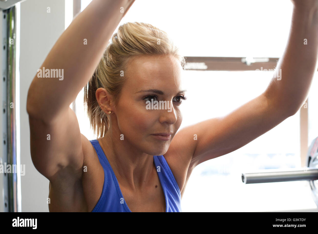 Femme dans une salle de sport à l'aide de machine d'exercice Banque D'Images